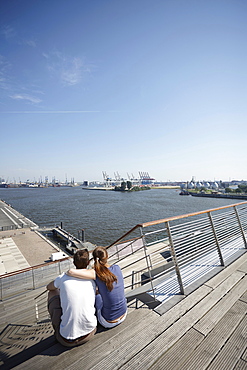 Couple on the terrace of Dockland, office building, near Altona fishing harbour, Hamburg, Germany