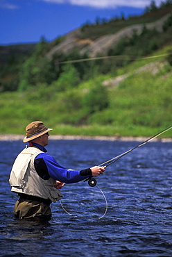 Fly Fisherman Casts into Northern Ontario River