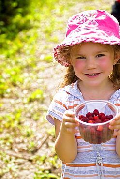 Girl holding container of raspberries, Lincoln Gardens, Lumsden, Saskatchewan