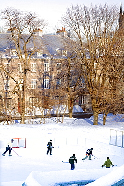 People playing hockey on an outside skating rink in winter, Quebec city