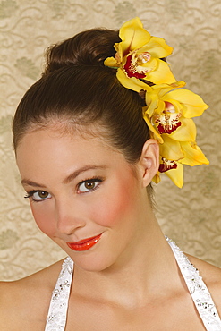 Hawaii, Portrait of young woman with orchids in hair.