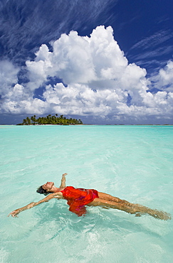 French Polynesia, Woman floating in ocean water.