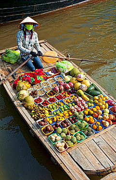 South East Asia, Vietnam, Ha Long Bay, Vietnamese woman sells fresh fruit from her small boat.