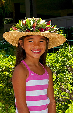 Hawaii, Oahu, Honolulu, Local young girl models a straw hat in her portrait.