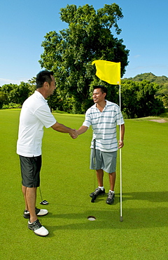 Hawaii, Oahu, Honolulu, Pali Golf Course, A local golfer congratulates his friend after making a good shot at hole 5.