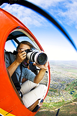 Hawaii, Maui, A female photographer shooting from a Helicopter.