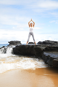 Hawaii, Oahu, Young girl on the beach excercising.