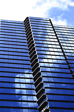 Hawaii, Oahu, Honolulu, Downtown financial district of a tower with the blue sky reflecting on windows.