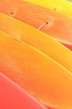 Hawaii, Oahu, Pattern shot of orange yellow Kayaks stacked on each other.