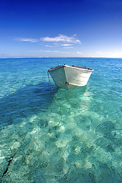 French Polynesia, Tahiti, Bora Bora, White boat floating on turquoise water.