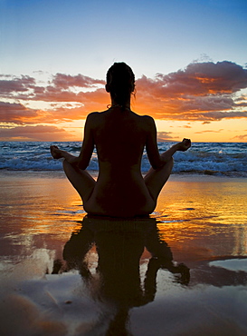 Hawaii, Maui, Silhouette of beautiful girl doing yoga on the beach.