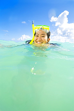 Hawaii, Oahu, Lanikai, Young Japanese woman wearing snorkle gear in the ocean.