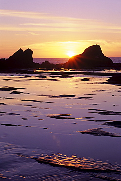 Oregon, Seal Rock, Sun setting over rocks and beautiful reflections.