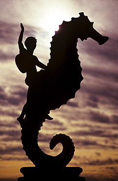 Mexico, Puerto Vallarta, Boy silhouette on large seahorse statue.