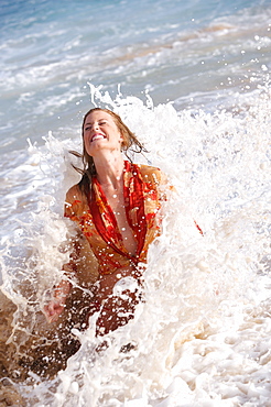 Hawaii, Oahu, girl getting splashed by a wave.