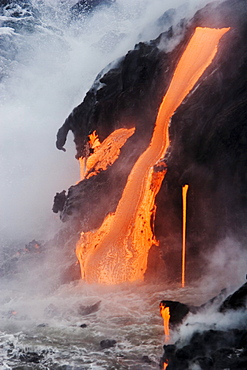 Hawaii, Big Island, near Kalapana, Pahoehoe lava flowing from Kilauea into Pacific Ocean, Steam rising.