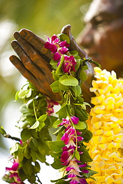 Hawaii, Oahu, Waikiki, Duke Kahanamoku statue draped with flowers.