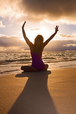 Hawaii, Oahu, Lanikai, woman doing yoga on the beach at sunrise.