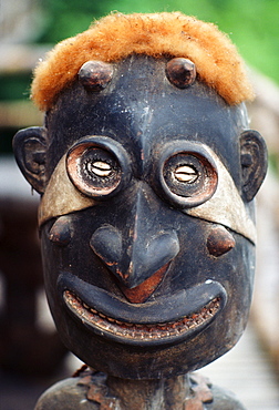 Papua New Guinea, close-up of wood statue, opossum fur on head