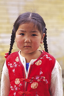 Mongolia, Ulaanbaatar, Small young local girl wearing red vest.