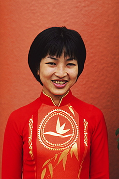 Vietnam, Ho Chi Minh City (Saigon), Portrait of beautiful local woman. dressed in red.