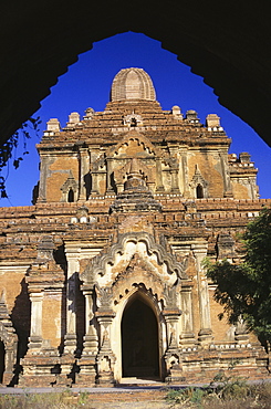 Burma (Myanmar), Old Bagan, Htilominlo Temple framed view from gateway, blue sky.