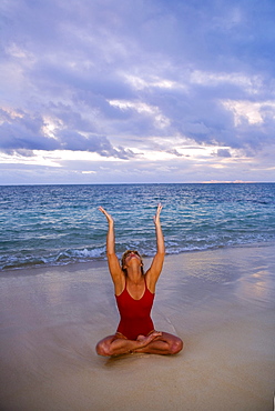 Hawaii, Oahu, Lanikai, woman doing yoga on the beach at sunrise.