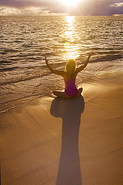 Hawaii, Oahu, Lanikai, woman doing yoga on the beach at sunrise.