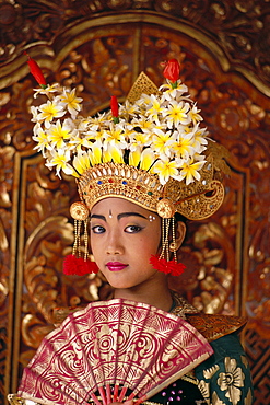 Indonesia, Bali, Legong Dancer young girl in traditional costume, holding fan 