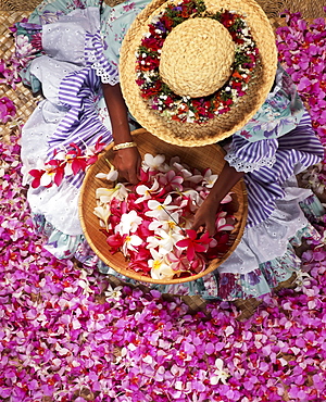 Hawaii, View from above woman with straw hat haku surrounded by orchids making lei 