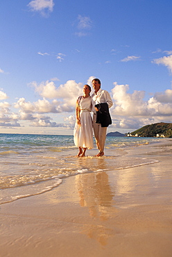 Couple at Walking by water dressed up Hawaii