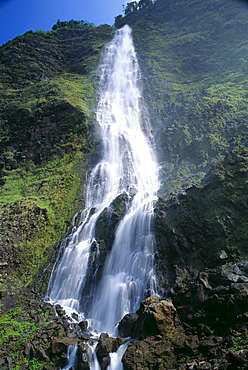 Hawaii, Big Island, Waipio Valley, Kaluahine Falls with rushing water action, blue sky C1652