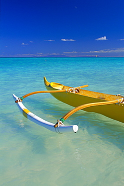 Hawaii, Oahu, Lanikai, close-up yellow canoe in turquoise ocean, Molokai visible background 