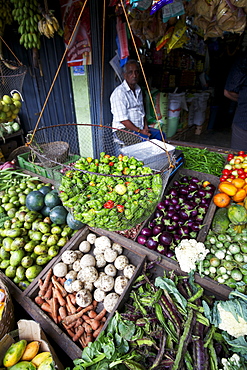 Traditionally dressed man selling vegetables on a street stall