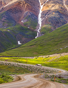 A semi-truck begins the ascent through Atigun Pass along the Dalton Highway; Alaska, United States of America