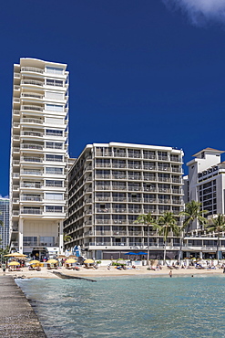 Castle Waikiki Shore (left), Outrigger Reef Waikiki Beach Resort (center), and Halekulani Hotel (far right) on Waikiki Beach, Waikiki, Honolulu, Oahu, Hawaii, United States of America