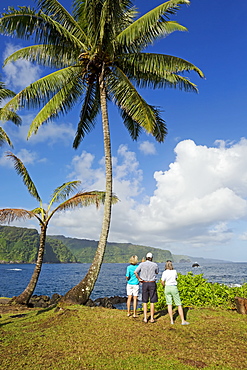 Three tourists looking at the North coast of Maui as viewed from Keanae, on the way to Hana, Maui, Hawaii, United States of America