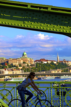 Cyclist on Liberty Bridge, Hungarian National Gallery in background, Budapest, Hungary, Europe