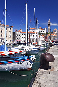 Waterfront buildings at the harbour and bell tower of Cathedral of St. George, Piran, Istria, Slovenia, Europe