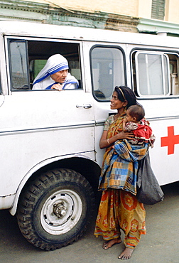 Mother Teresa talking with a poor woman and her child from a Red Cross minibus in Calcutta, India