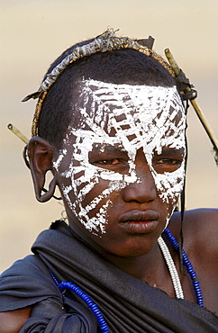 Young recently circumcised Masai Warrior (moran) with traditional face paint after 'coming of age'  in the Serengei Plains, Tanzania