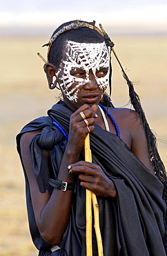 Young recently circumcised Masai Warrior (moran) with traditional face paint after 'coming of age'  in the Serengei Plains, Tanzania