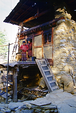 Father and son stand in doorway of their home in Paro, Bhutan