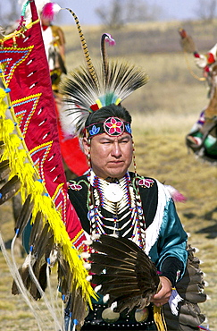 CANADIAN PLAINS INDIAN IN TRADITIONAL COSTUME
AND FEATHER HEAD-DRESS AND CARRYING A FEATHER
FAN AT WANUSKEWIN HERITAGE PARK, SASKATOON , CANADA.