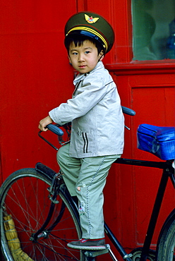 Young boy playing on a bicycle, Beijing, China