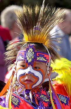 Cree Indian child, First Nation Canadian, in traditional costume with face painted at heritage display in Regina, Canada