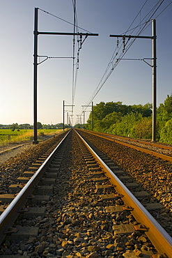 Train track and overhead cables  at  level crossing near Barsac station, Bordeaux  region, France.