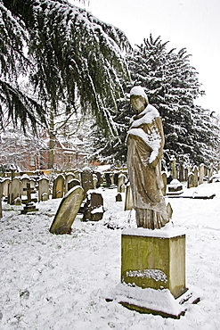 Snow covered monument and gravestones in Hampstead Parish churchyard, London, United Kingdom