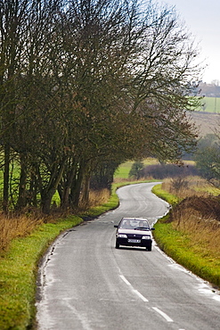 Car driving on a country road near Burford in the Cotswolds, Oxfordshire, United Kingdom