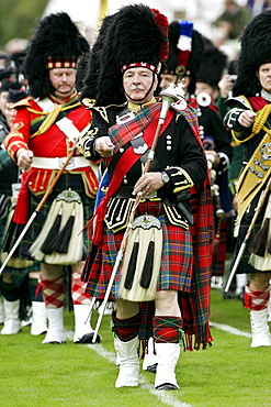 Drum Major leads massed band of Scottish pipers at Braemar Games Highland Gathering